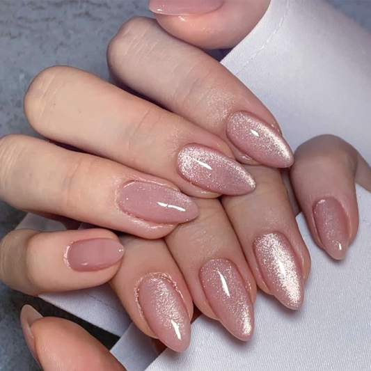 Close-up of hands with pink glittery nail polish on a neutral background