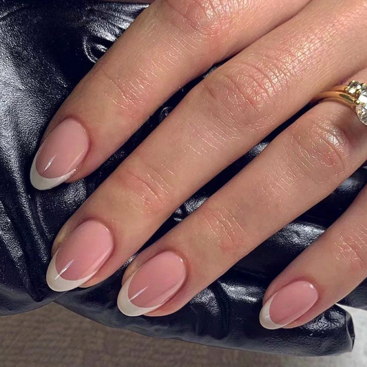 Close-up of a hand with pink and white nail polish on a dark textured background