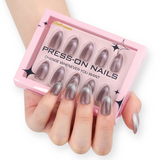 Set of press-on nails in a pink packaging box held by a hand.