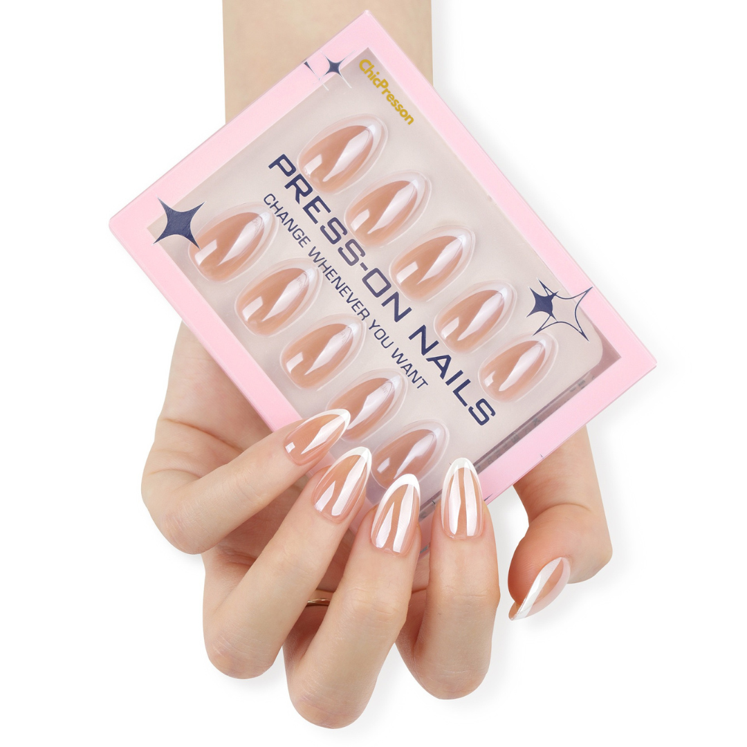 Set of press-on nails with a pink packaging box held by a hand.