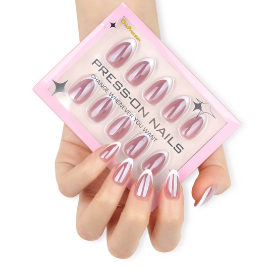Press-on nails in a pink packaging held by a hand with matching nails.