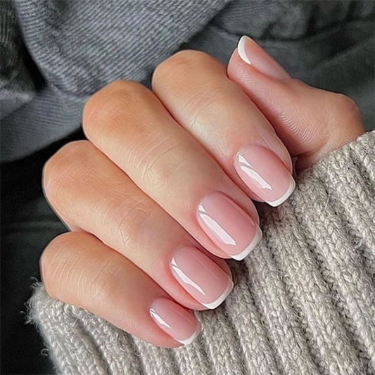 Close-up of a hand with pink nail polish on a textured fabric background